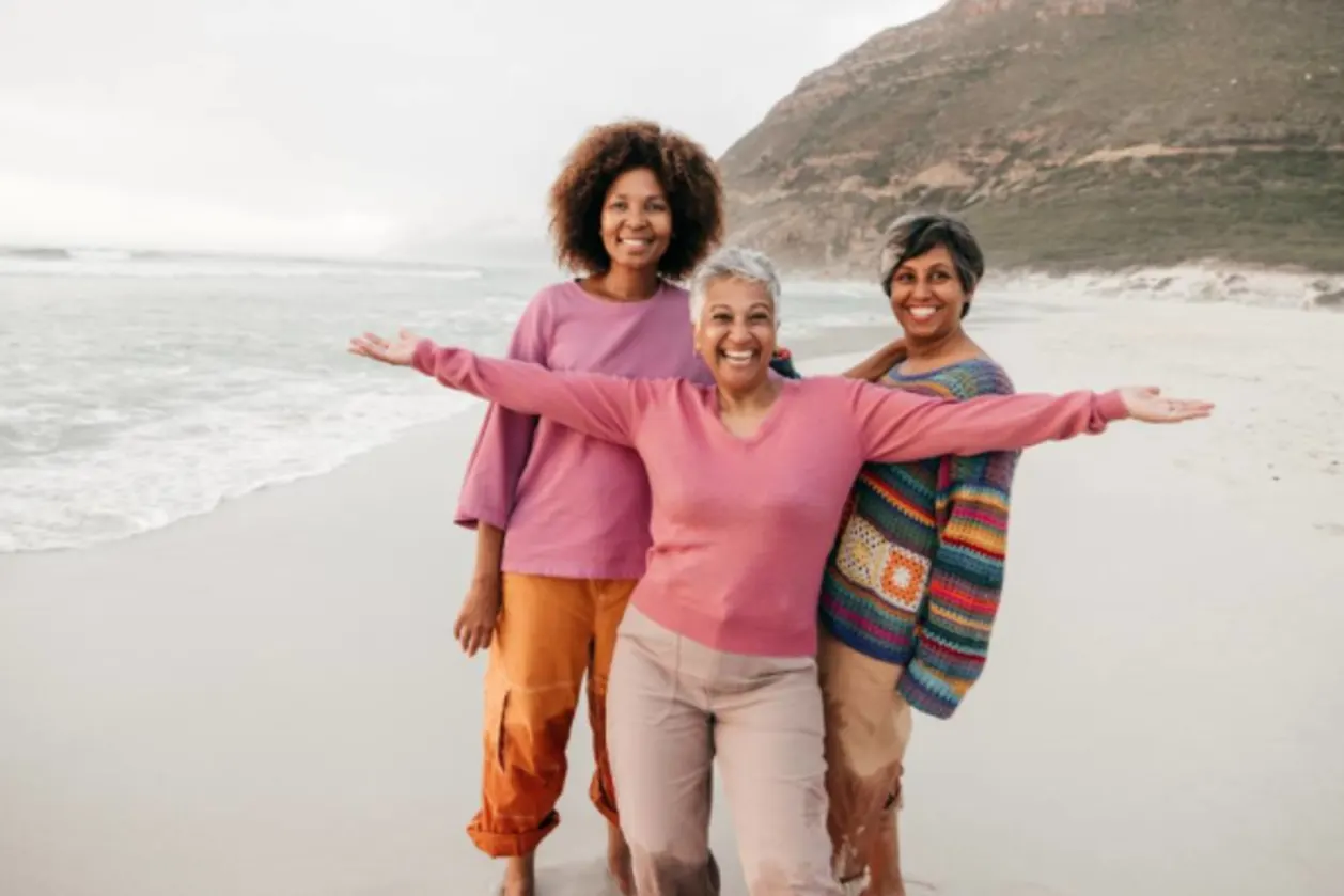 Three menopausal women of color on beach